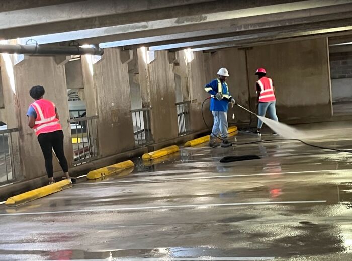 Crew member with a backpack blower clearing a garage level at night