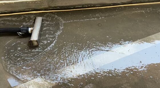 Water recovery vacuum head collecting wash water from a garage deck